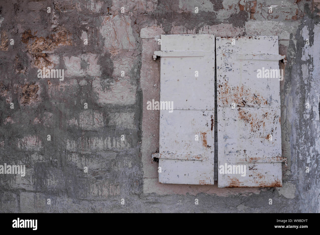 Dans l'ancien bâtiment du centre historique de la ville, fait de pierres afin d'éviter que la chaleur. Fenêtre avec un volet fermé. Sibenik, Croatie. Banque D'Images