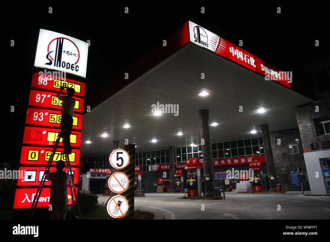 Un travailleur chinois station-service mises des prix de l'essence à une station-service de Sinopec à Beijing, Chine, lundi 1er juin 2009. La Chine a augmenté les prix du carburant Banque D'Images