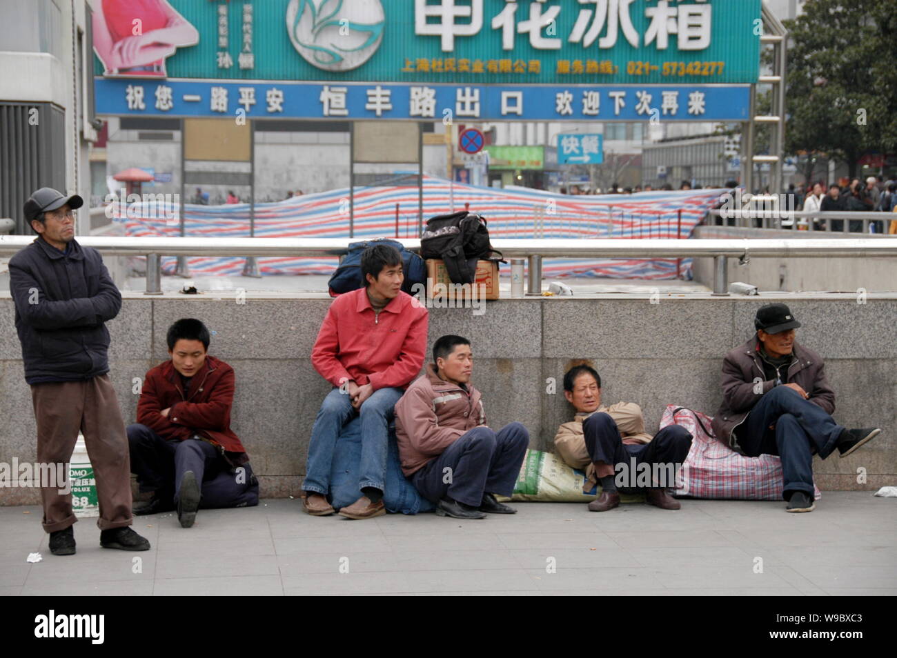 Les travailleurs migrants chinois sans emploi alors que l'écart près de la gare de Shanghai à Shanghai, Chine, dimanche, 15 février 2009. Chines de syndicats ont besoin Banque D'Images