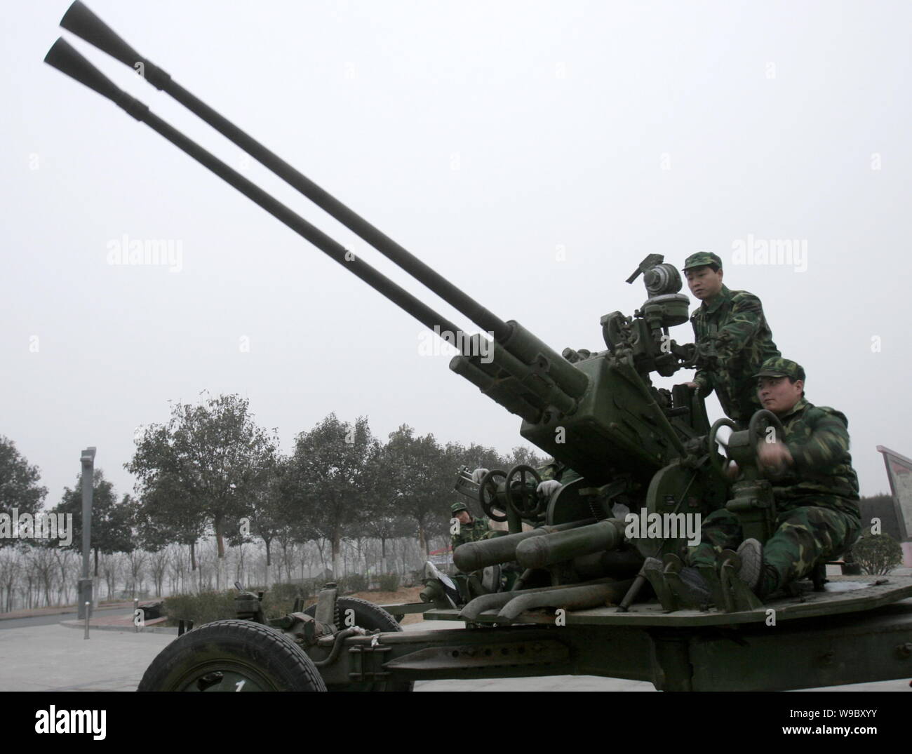 Les travailleurs chinois locaux service météorologique de préparer une artillerie anti-aérienne essaie de nuages de pluie artificielle de semences pour faciliter la sécheresse je Banque D'Images