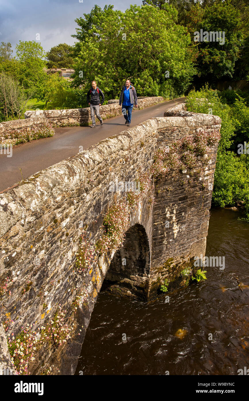 Royaume-uni, Angleterre, Devon, Staverton, deux hommes marcheurs crossing vieux pont de pierre sur la rivière Dart Banque D'Images