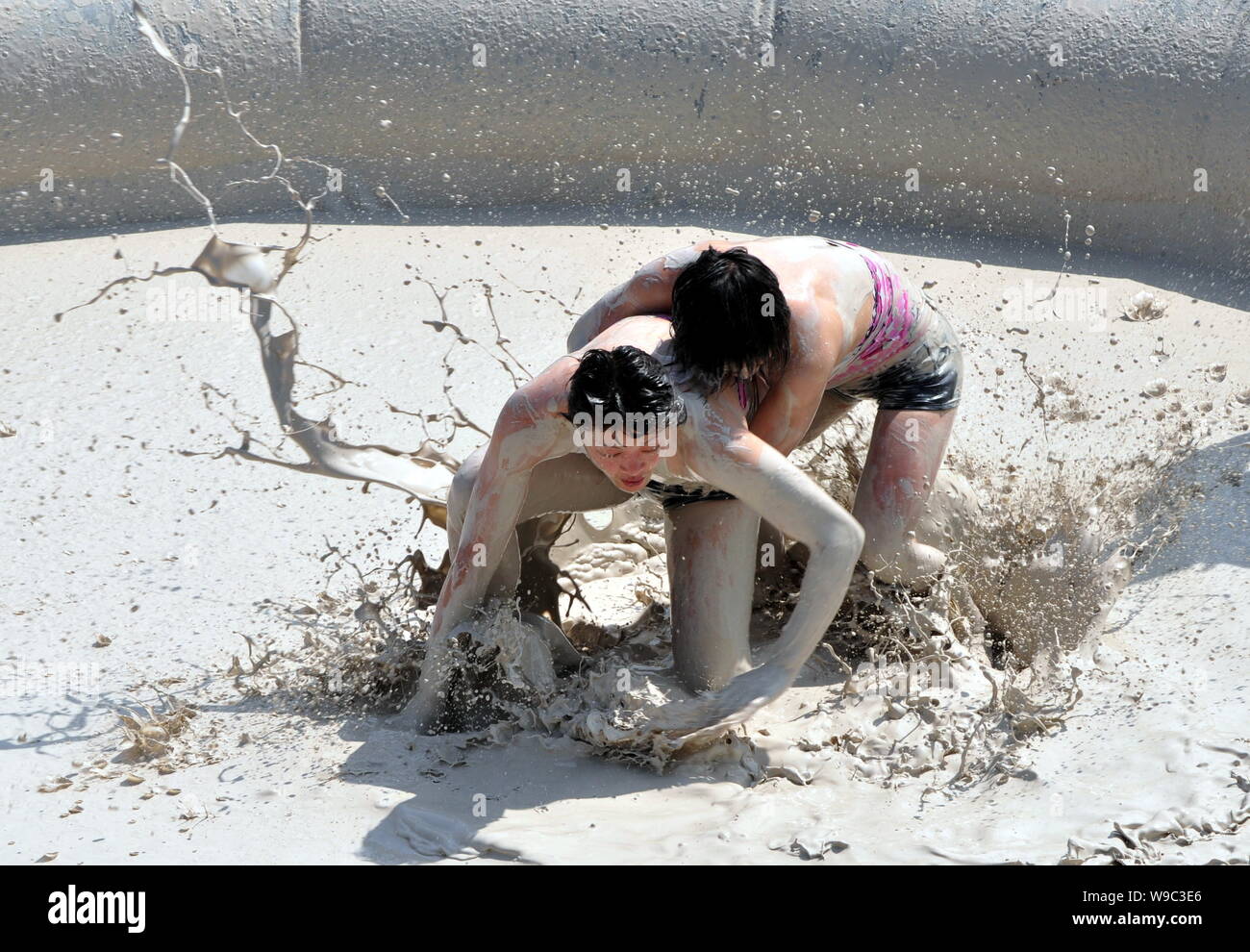 Deux femmes chinoises se débattre dans une piscine de boue lors d'un concours international womens wrestling de boue le long du lac de l'est à Wuhan, Hubei Chine centrale pr Banque D'Images