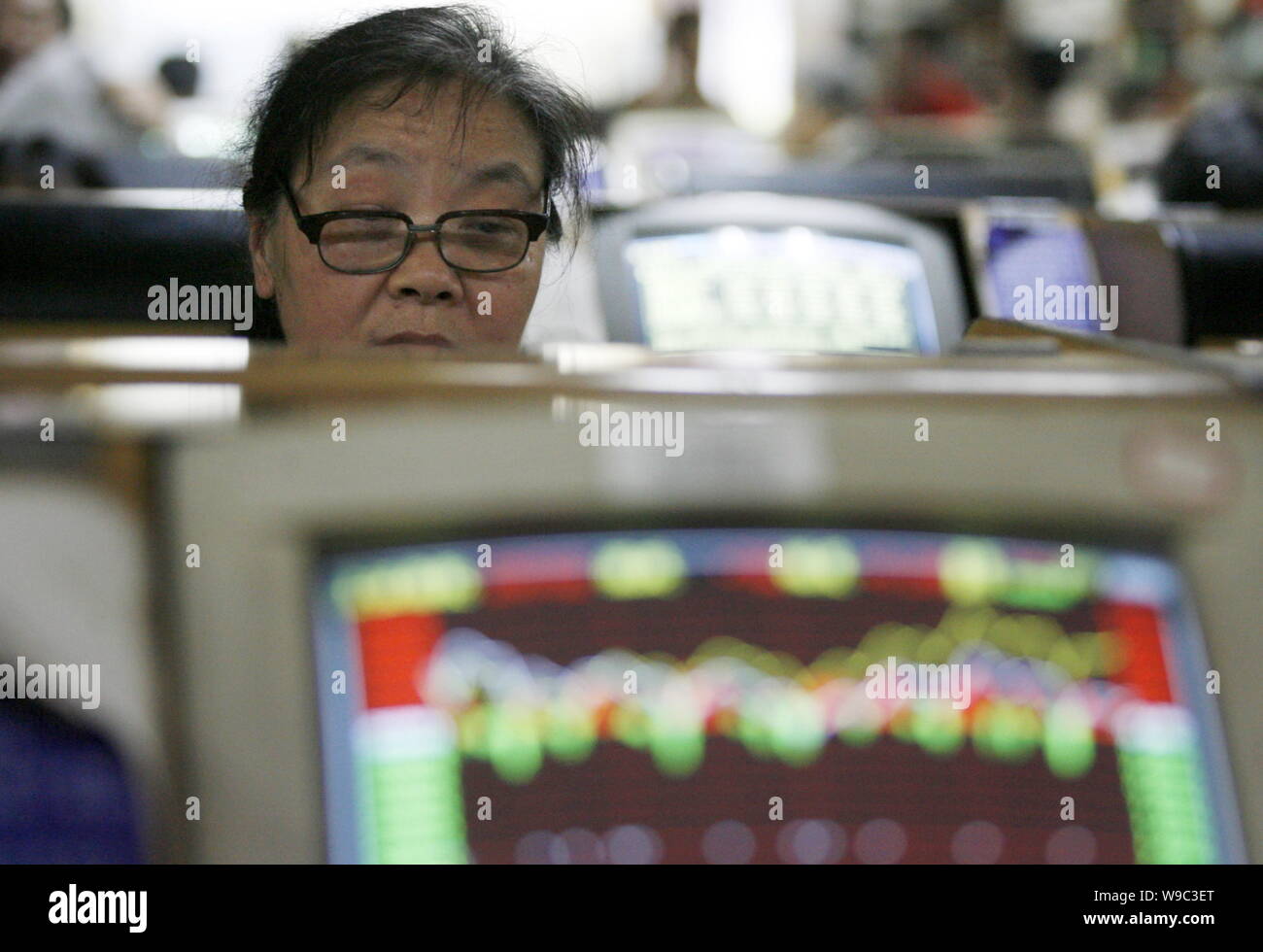 --FILE--un investisseur chinois se penche sur le prix des actions à une maison de courtage à Chongqing, Chine, le 5 mai 2009. L'opérateur de la Nasdaq Stock Market Banque D'Images