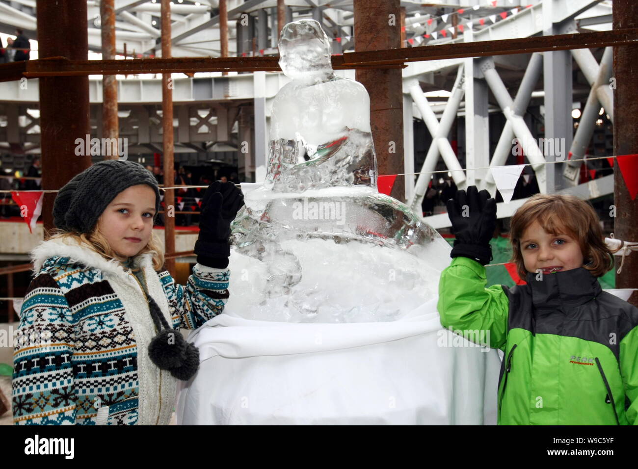 Les enfants danois poser à côté d'une sculpture de glace de la Petite Sirène au Danemark Pavillon à Shanghai, Chine, le lundi 30 novembre 2009. Le Danemark s'b Banque D'Images