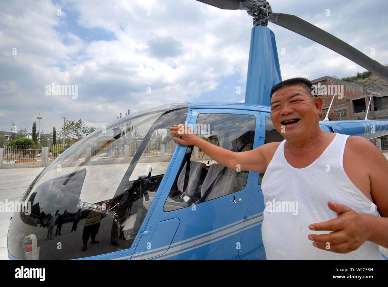 Paysan chinois Chen Minggang entrepreneur se trouve à côté de son nouveau acheté Robinson R44 RAVEN II) dans le village de chaulage, Chengguan town, Jing Banque D'Images