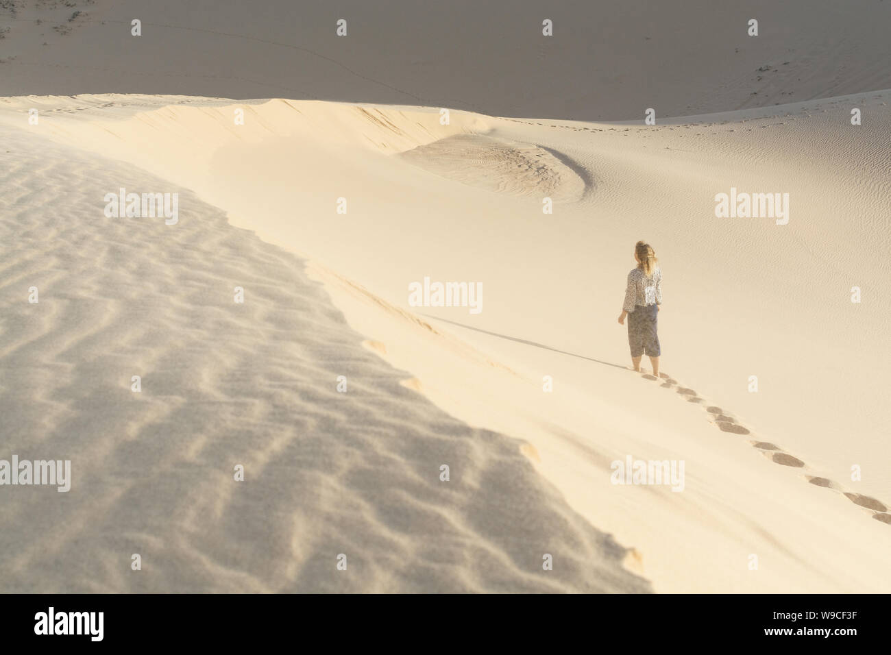 Balades silhouette de femme dans les dunes de sable du désert de Mui Ne, Vietnam. Banque D'Images
