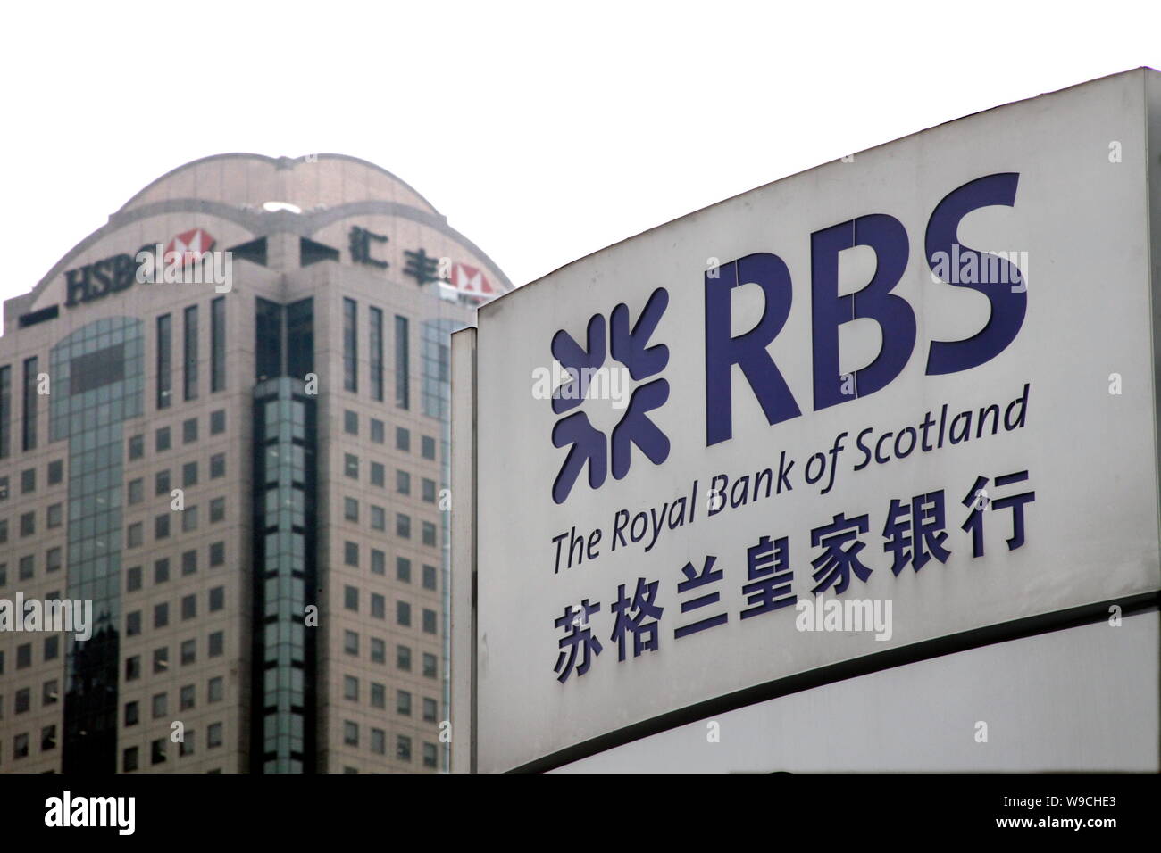 Vue de la plaque du constructeur de la Royal Bank of Scotland (RBS), avec la tour HSBC vu dans l'arrière-plan, à Shanghai, Chine, le 11 décembre 2009. HSBC Banque D'Images