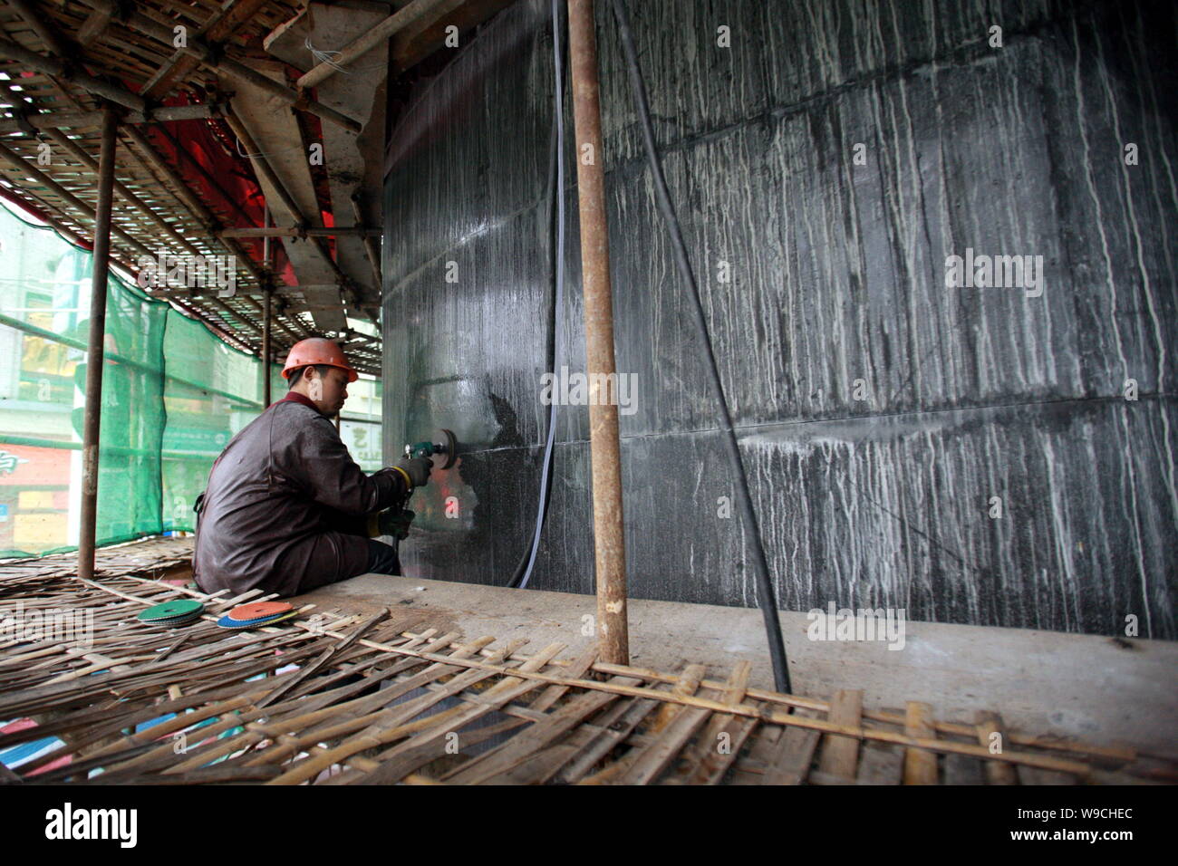 Un travailleur chinois granites polis sur la façade de l'Hôtel Du Parc en cours de rénovation à Shanghai, Chine, le 8 décembre 2009. Le Park Hotel, le plus haut Banque D'Images