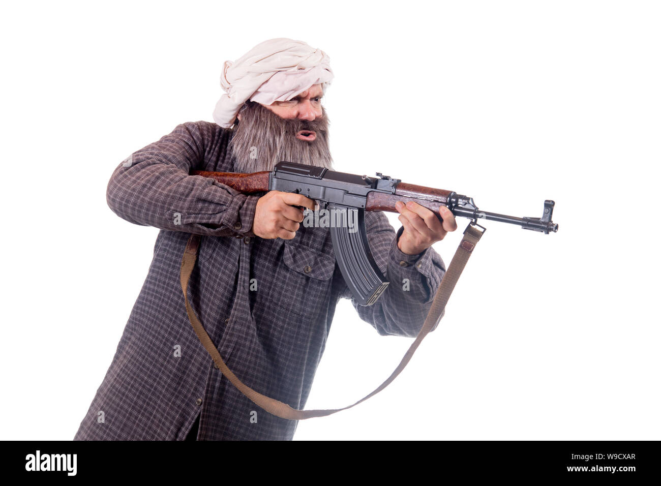 Le barbu armés de Kalachnikov isolé sur un fond blanc. Guerrier musulman avec arme automatique. Banque D'Images