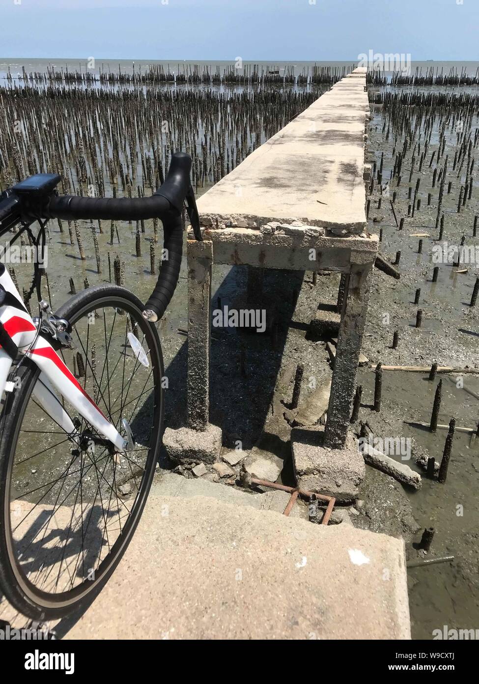 Le vélo à la fin de la voie par la mer. Broken Road sur la côte avec une protection contre l'érosion des terres, la Thaïlande. Banque D'Images