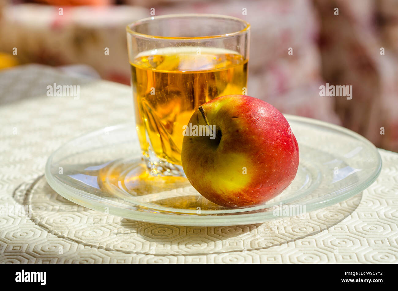 Une pomme et un verre de jus de pomme ensemble sur une table. Banque D'Images