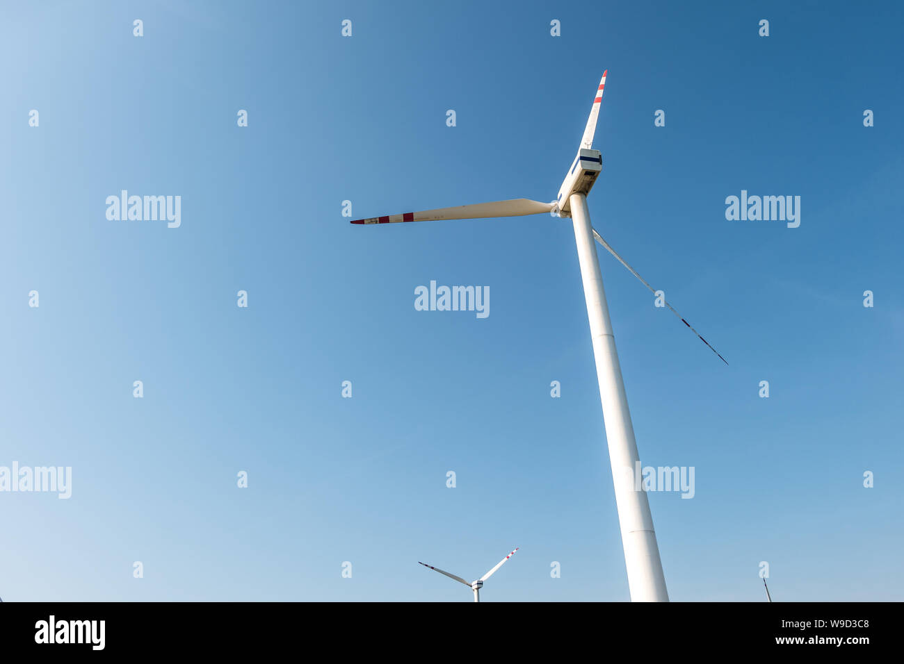 Les lames en rotation d'une hélice moulin sur fond de ciel bleu. La production d'énergie éolienne. L'énergie verte. Banque D'Images