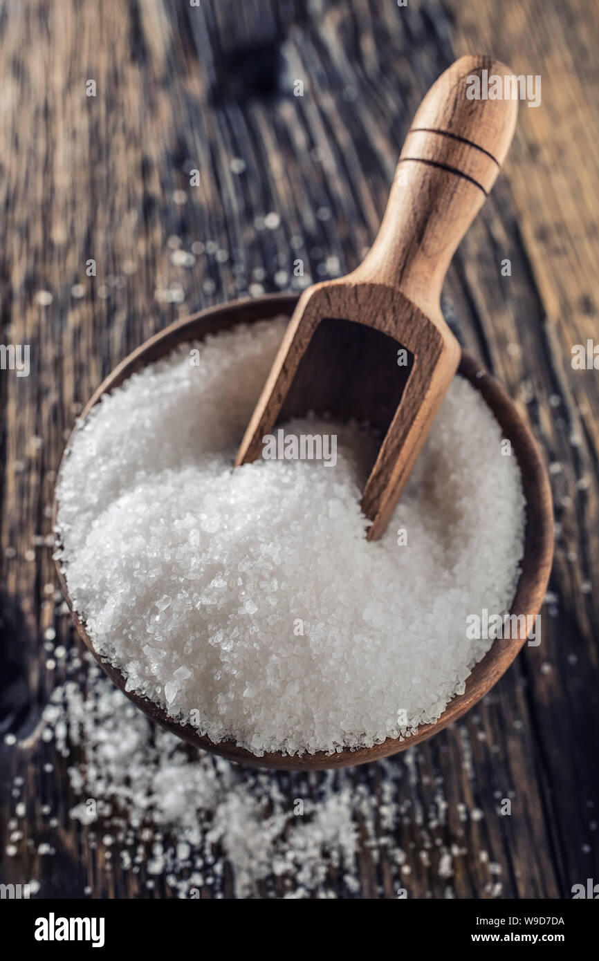 Gros grain de sel dans un bol en bois avec une louche sur une vieille table en chêne Banque D'Images