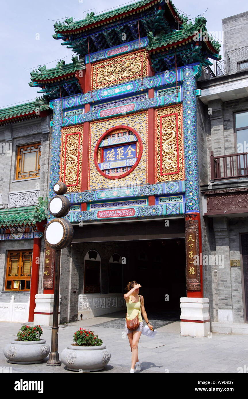 --FILE--une femme entre un passé Quanjude Roast Duck restaurant sur la rue Qianmen à Pékin, Chine, 15 juillet 2009. Quanjude, le célèbre roas chinois Banque D'Images