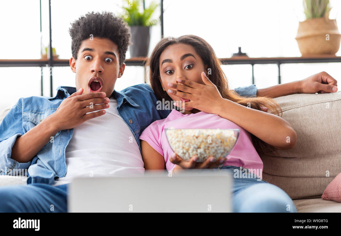 Black couple émotionnel regarder film d'horreur on laptop Banque D'Images