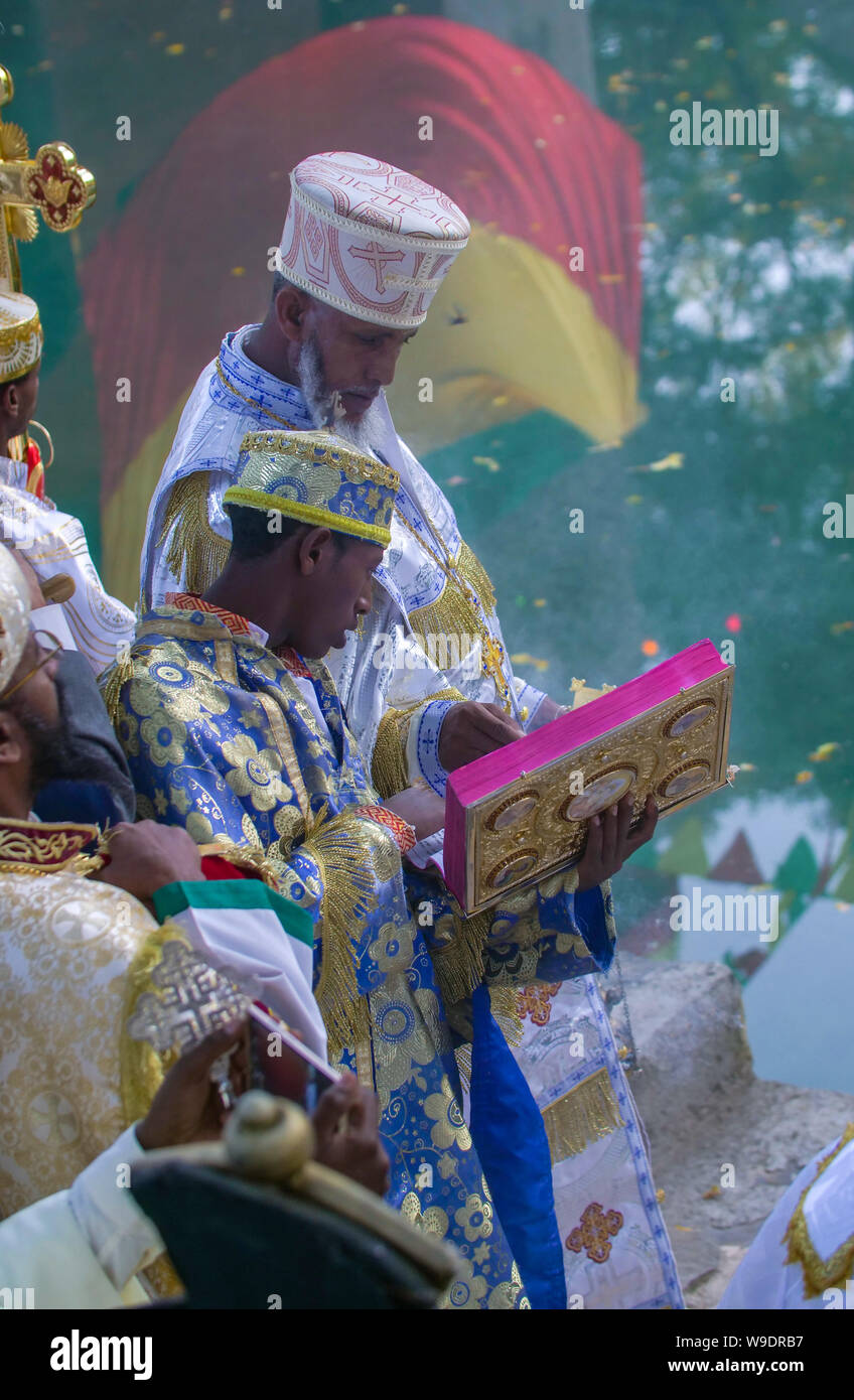 Gonder, Ethiopie, le 18 janvier 2019 : Prêtre habillé en tenue traditionnelle de célébrer le festival Timkat, par la lecture d'une bible en amharique Banque D'Images