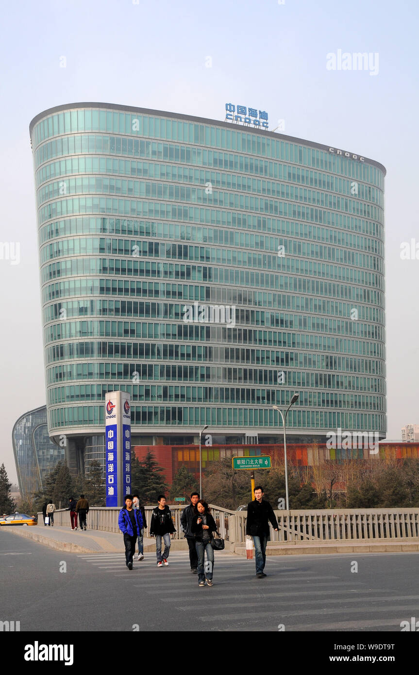 --FILE--Local des résidents chinois à pied par le siège et siège social de la CNOOC (China National Offshore Oil Corporation) à Beijing, Mars Banque D'Images