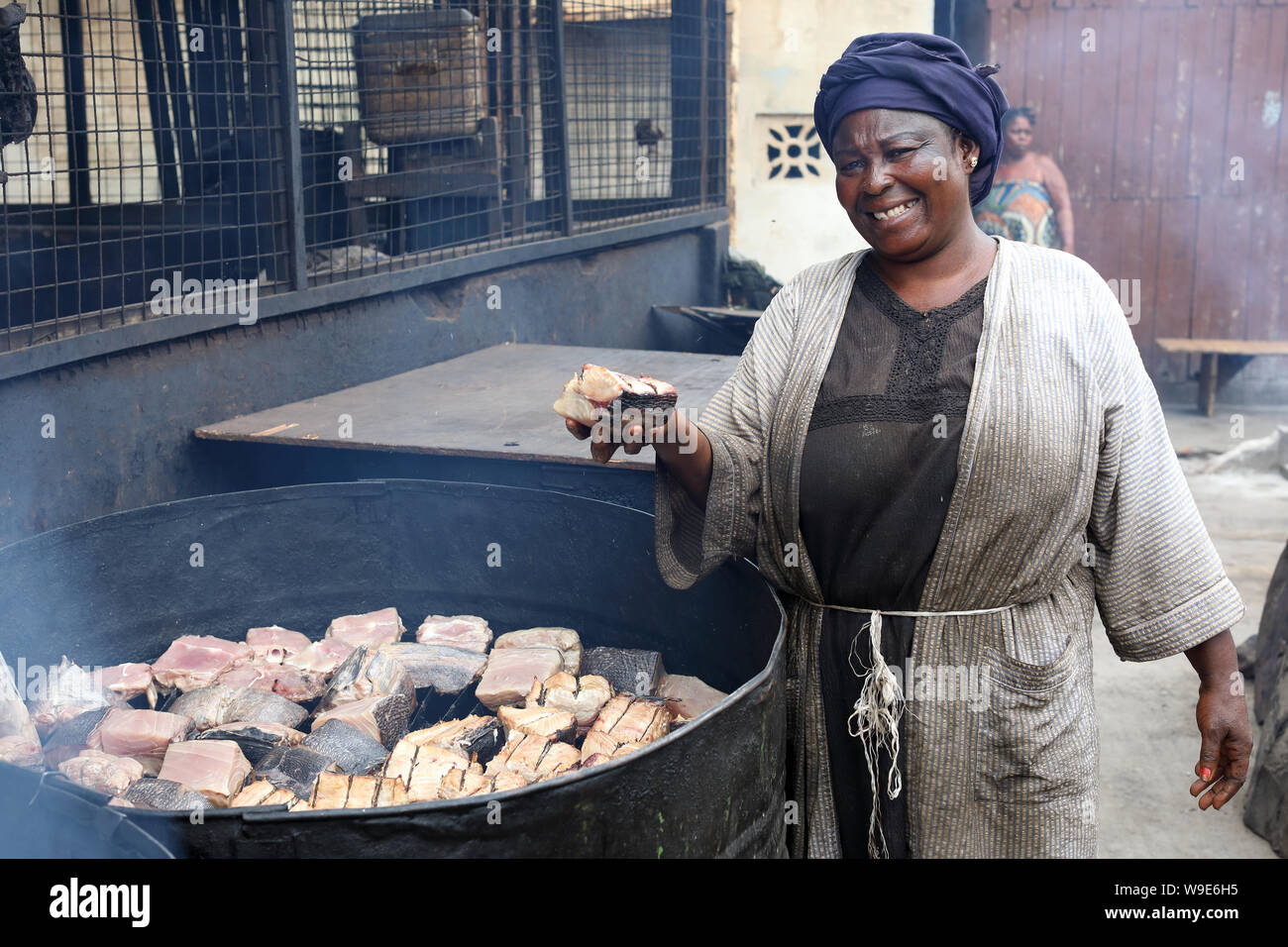 Femme marché vend des poissons fumés dans le village de pêcheurs Jamestown, à Accra, Ghana Banque D'Images