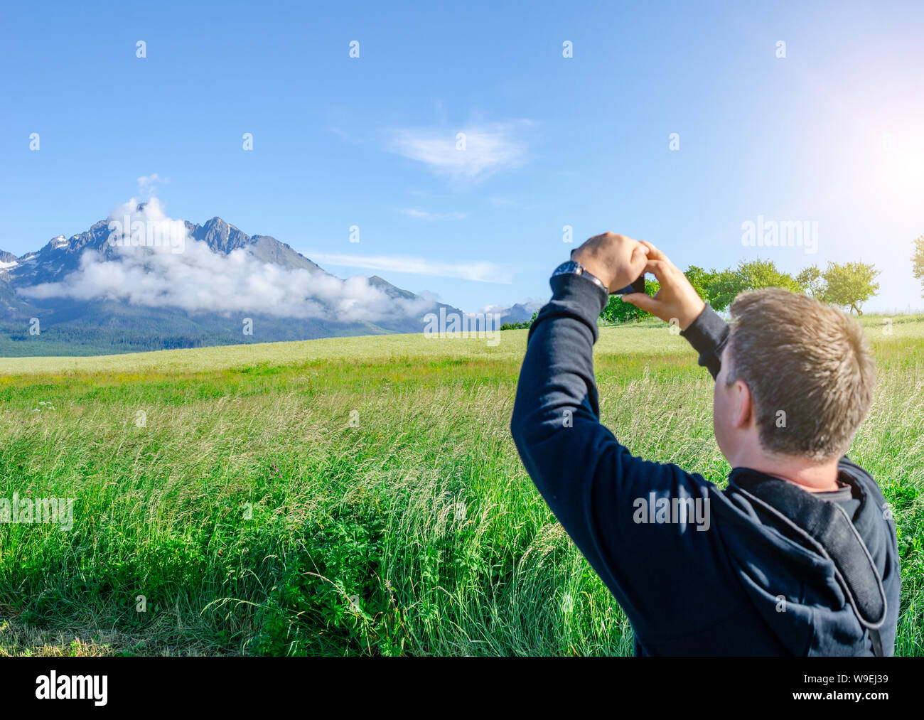Photographies touristiques mâle un paysage de montagne sur un smartphone. Banque D'Images