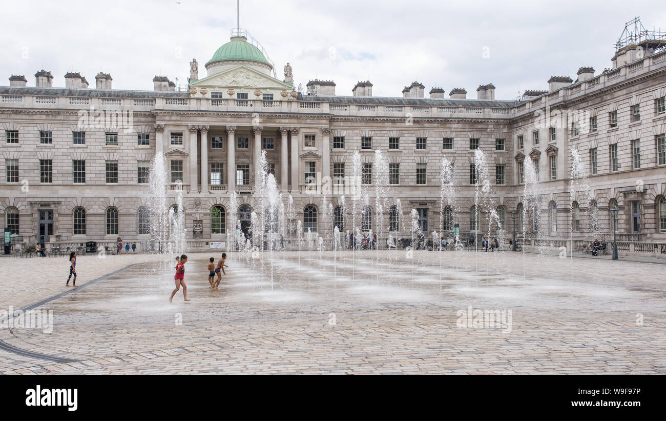 Londres, Angleterre - Mai 2019 : les enfants jouent avec de l'eau des fontaines dans la cour de Somerset House, Londres UK Banque D'Images