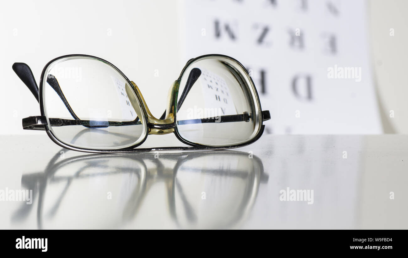 Vieux verres sur une table dans une pièce blanche. Banque D'Images