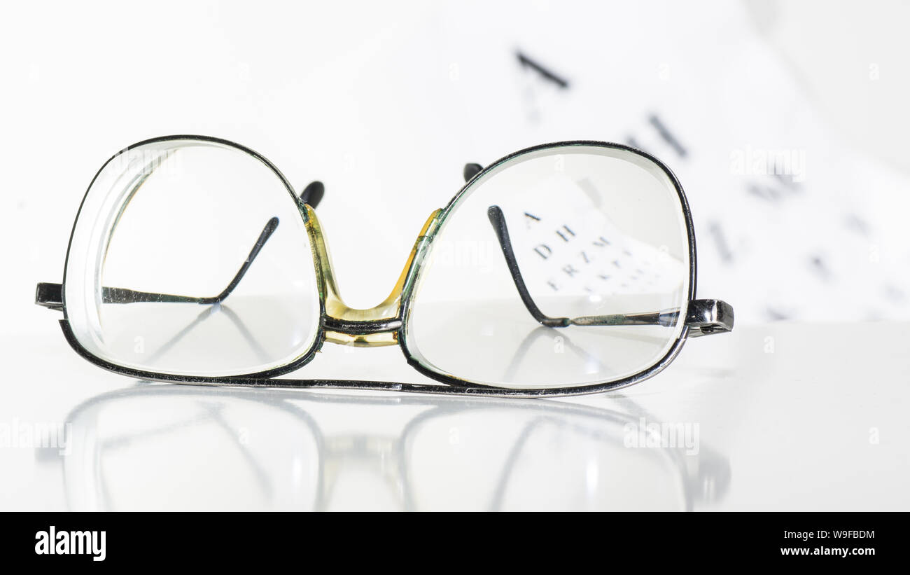 Vieux verres sur une table dans une pièce blanche. Banque D'Images