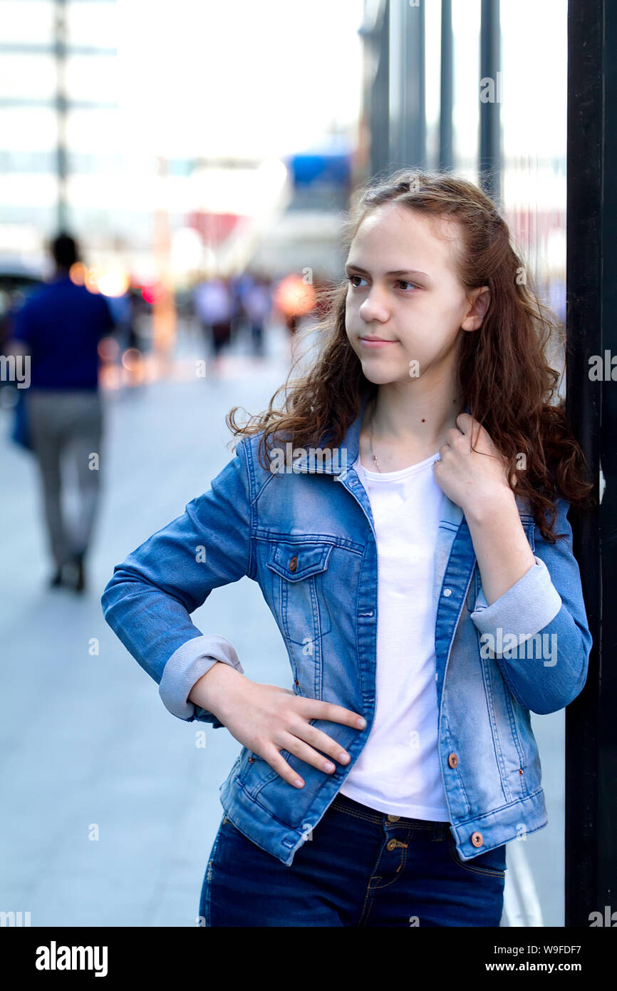 Teen girl sur un édifice de verre dans la rue. Banque D'Images