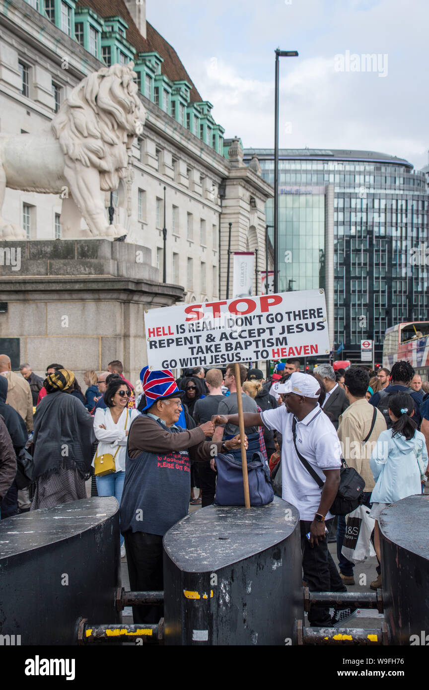 Le christianisme la religion propagée sur le pont de Westminster juste en dehors de la procédure d'attraction London eye Banque D'Images