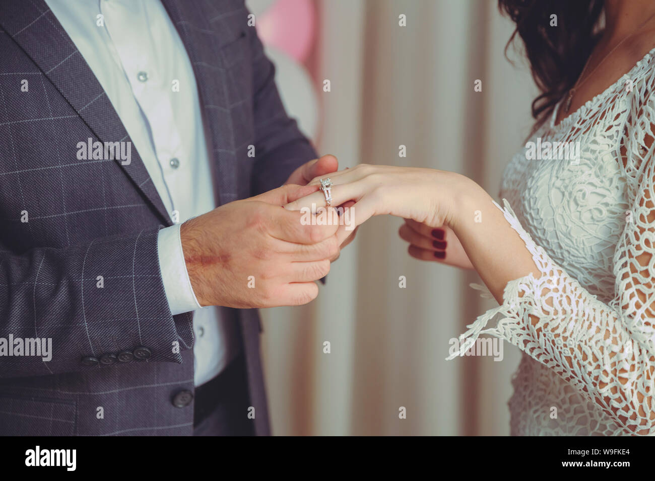 Met une bague sur la main de la Mariée . Groom met anneau de mariage sur la main de la mariée à l'église .homme met un anneau de mariage sur un côté de la mariée, close-up photo Banque D'Images