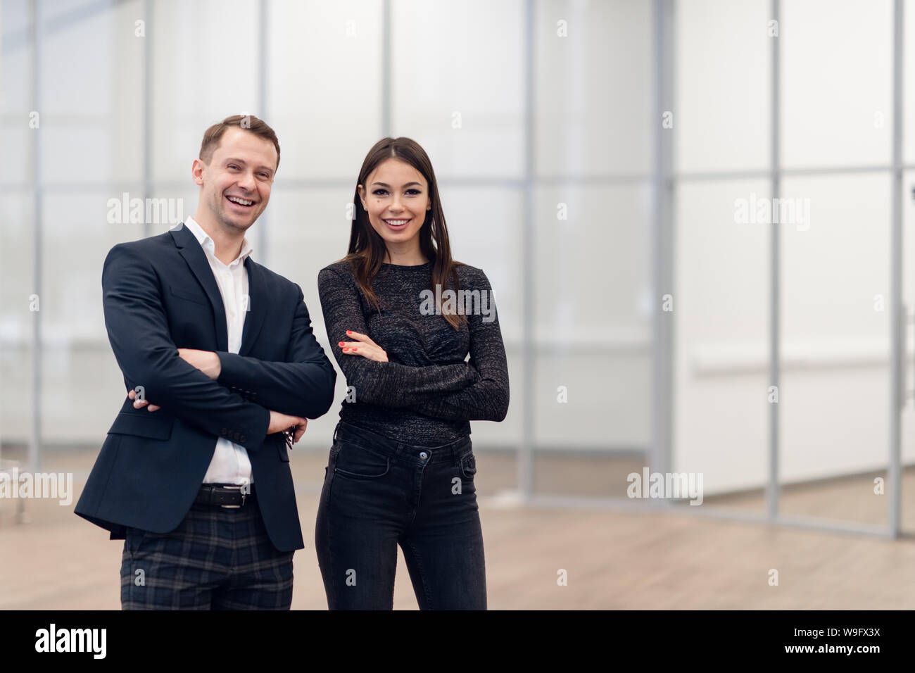 Un homme d'affaires et femme debout dos à dos avec des sourires sur leurs visages Banque D'Images