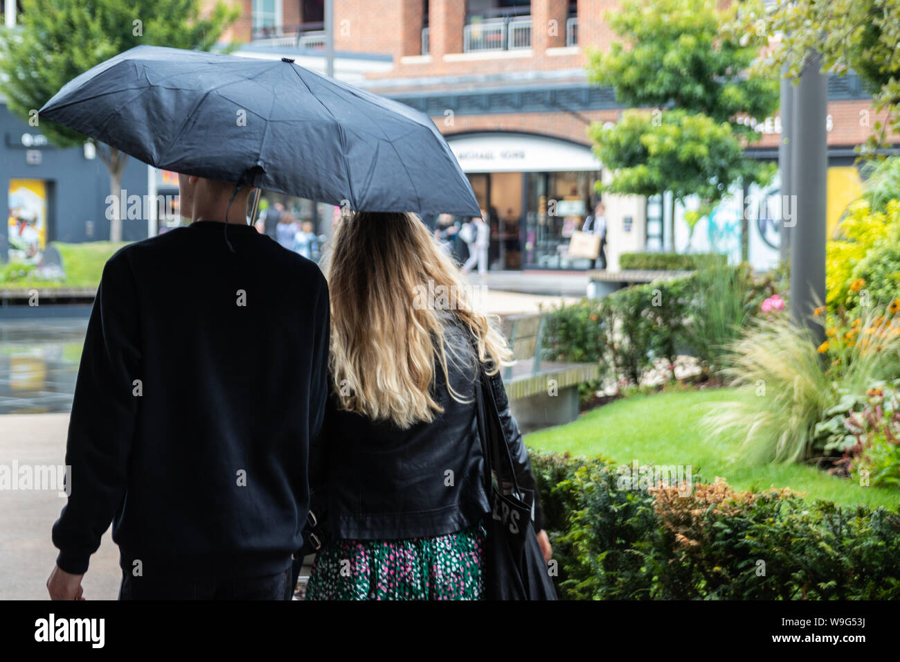 Un couple en train de marcher ensemble sous un parapluie en cas de pluie Banque D'Images