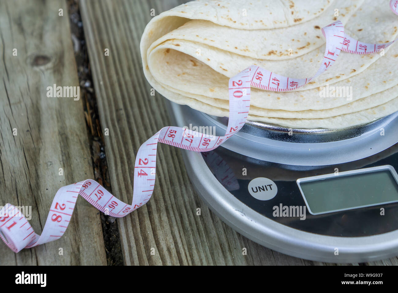 Bas carb tortillas sur une échelle d'aliments avec un ruban à mesurer sur fond de bois. Chambre vide vide pour le texte ou copiez l'espace. L'alimentation santé saine tendance pour ke Banque D'Images