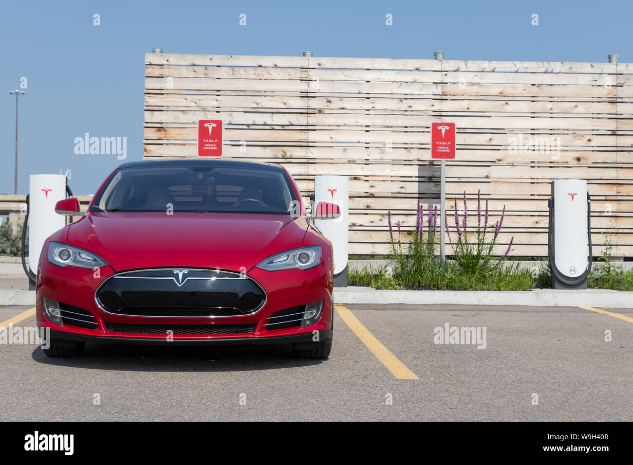 L'avant de 2014 Tesla Model S Rouge pendant le chargement à Tesla surcompresseur. Urbaine Banque D'Images