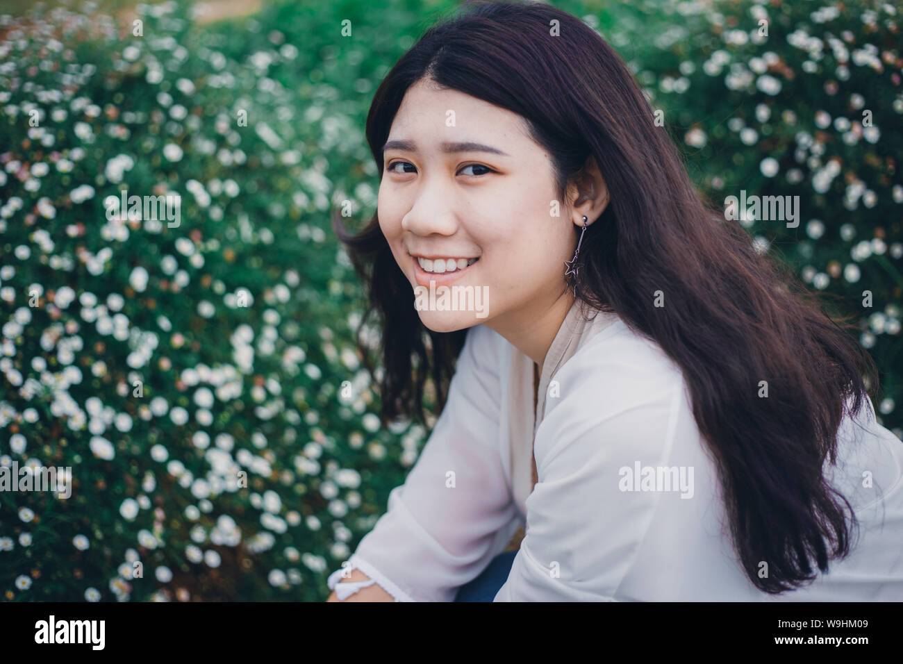 Cute Asian Fat Girl Young Smiling avec dents en bonne santé dans le champ de fleurs jardin vintage color tone Banque D'Images