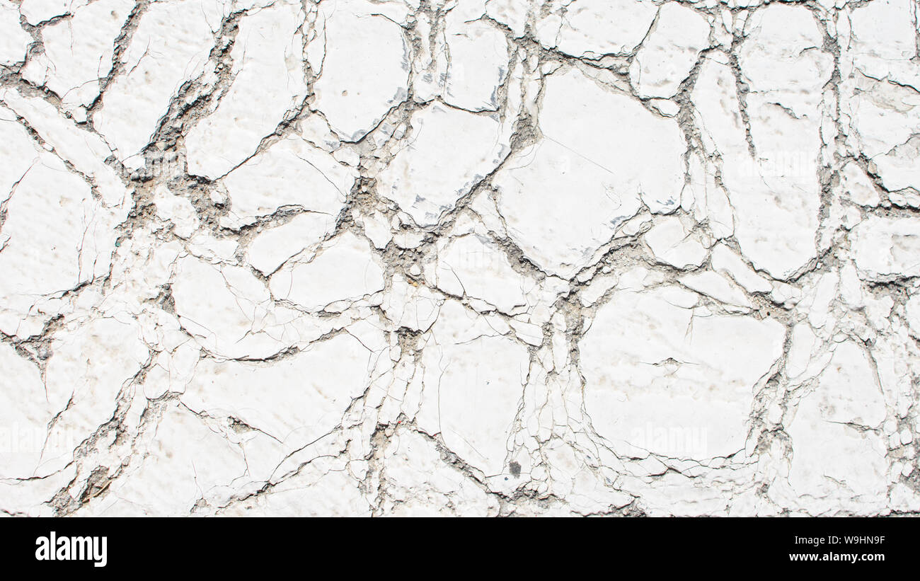 Ancienne peinture blanc craquelé, fissuré par la chaleur dans le soleil, sur la surface du béton. Grand pour la conception et la texture de fond. Banque D'Images
