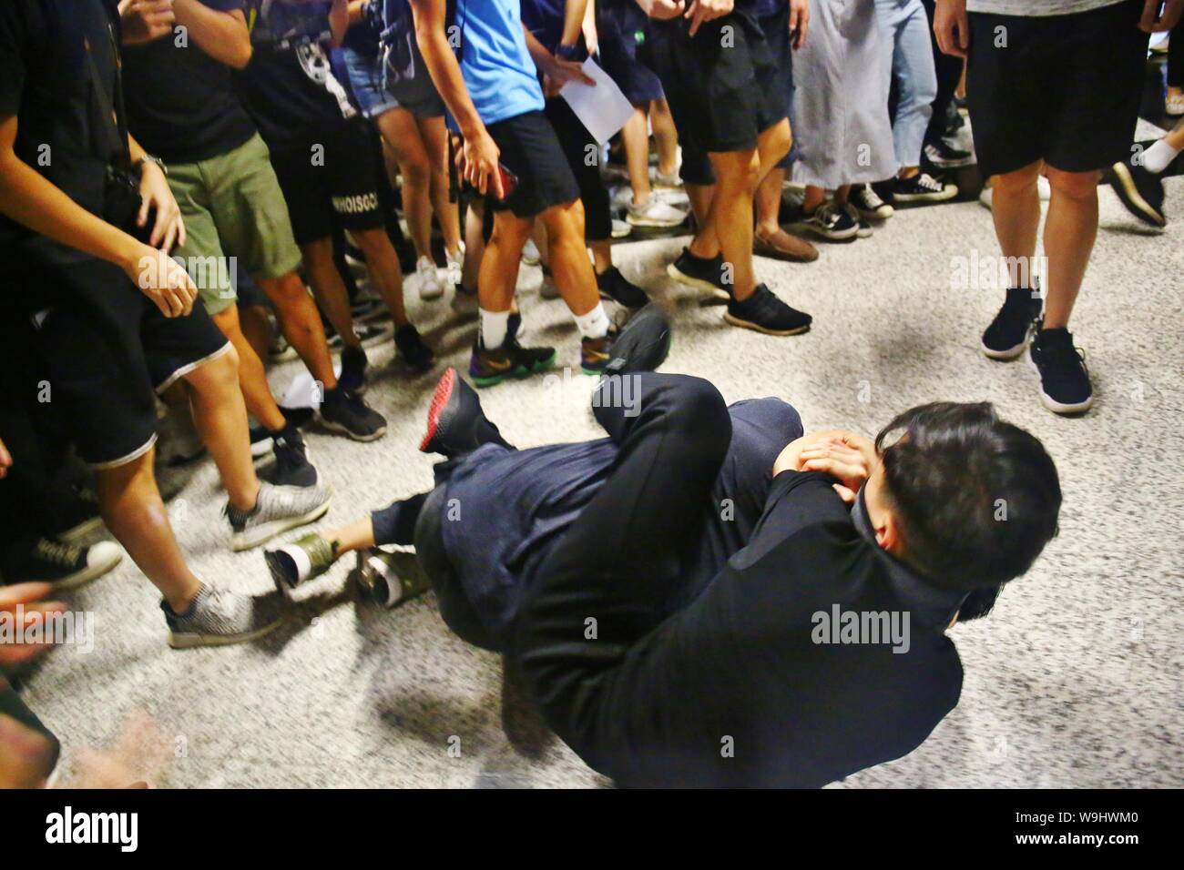 Hong Kong. Août 13, 2019. Ici un chinois de la Chine continentale est soupçonné d'être agent secret, et il est entouré et frappé par des manifestants en colère. Une carte d'identité de la Chine continentale se trouve dans son sac et il est par la suite envoyé à l'hôpital. Gonzales : Crédit Photo/Alamy Live News Banque D'Images