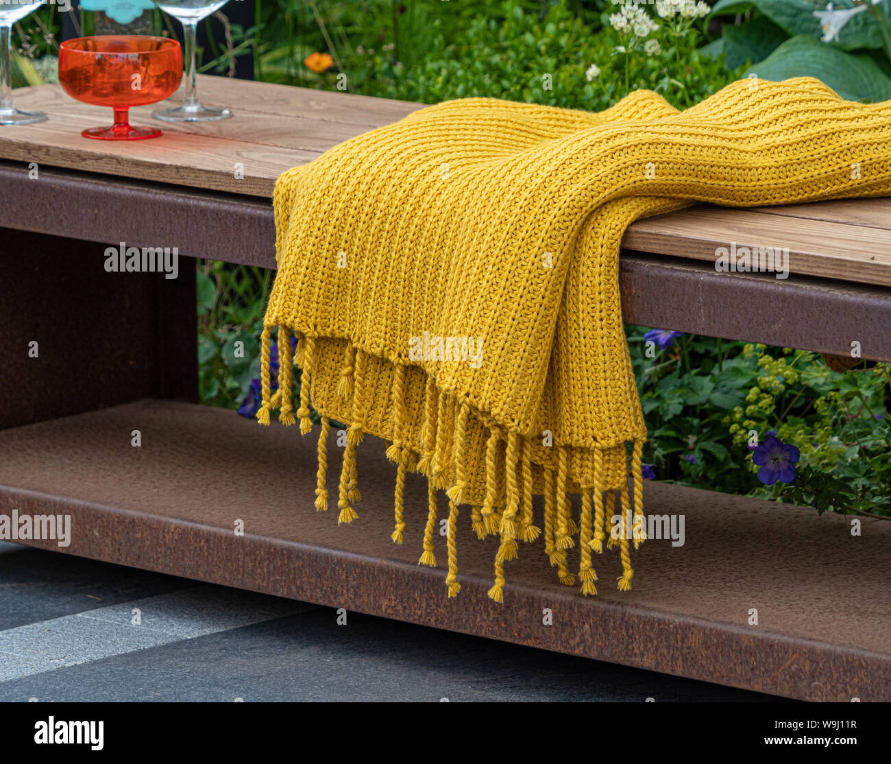 Piscine bois et métal gris sur banc de jardin patio en pierre avec tissu de  couleur moutarde jeter et verres Photo Stock - Alamy