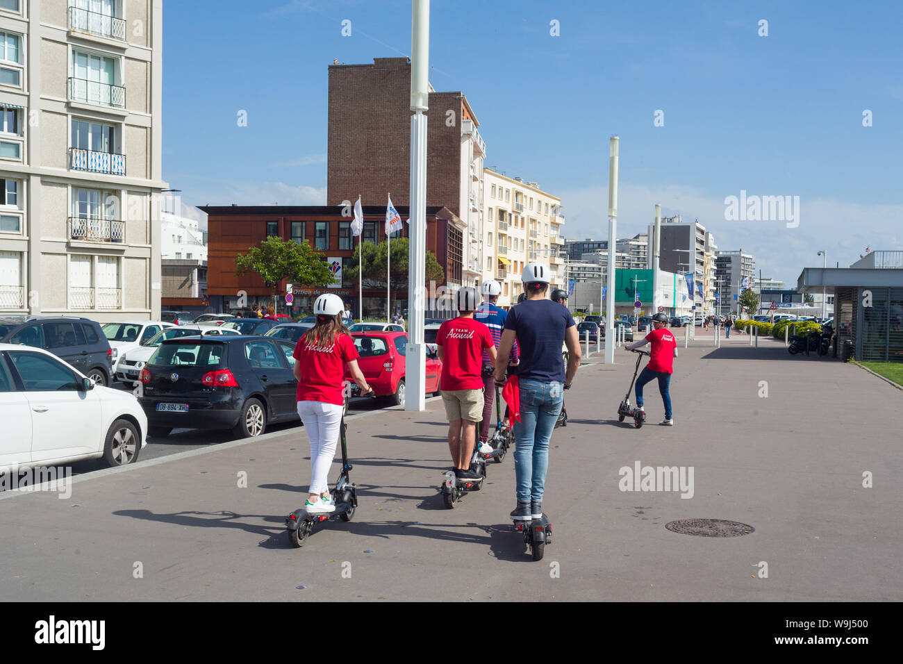 Une partie de jeunes touristes sur le front de mer au Havre, Normandie, France sur e-scooters, ou des scooters électriques. Banque D'Images