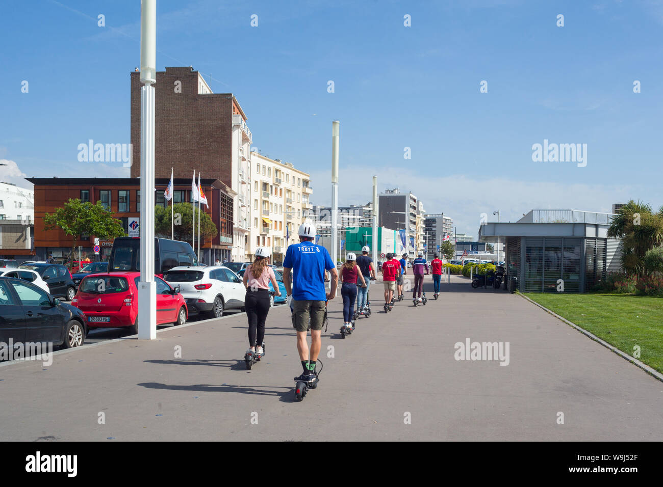 Une partie de jeunes touristes sur le front de mer au Havre, Normandie, France sur e-scooters, ou des scooters électriques. Banque D'Images