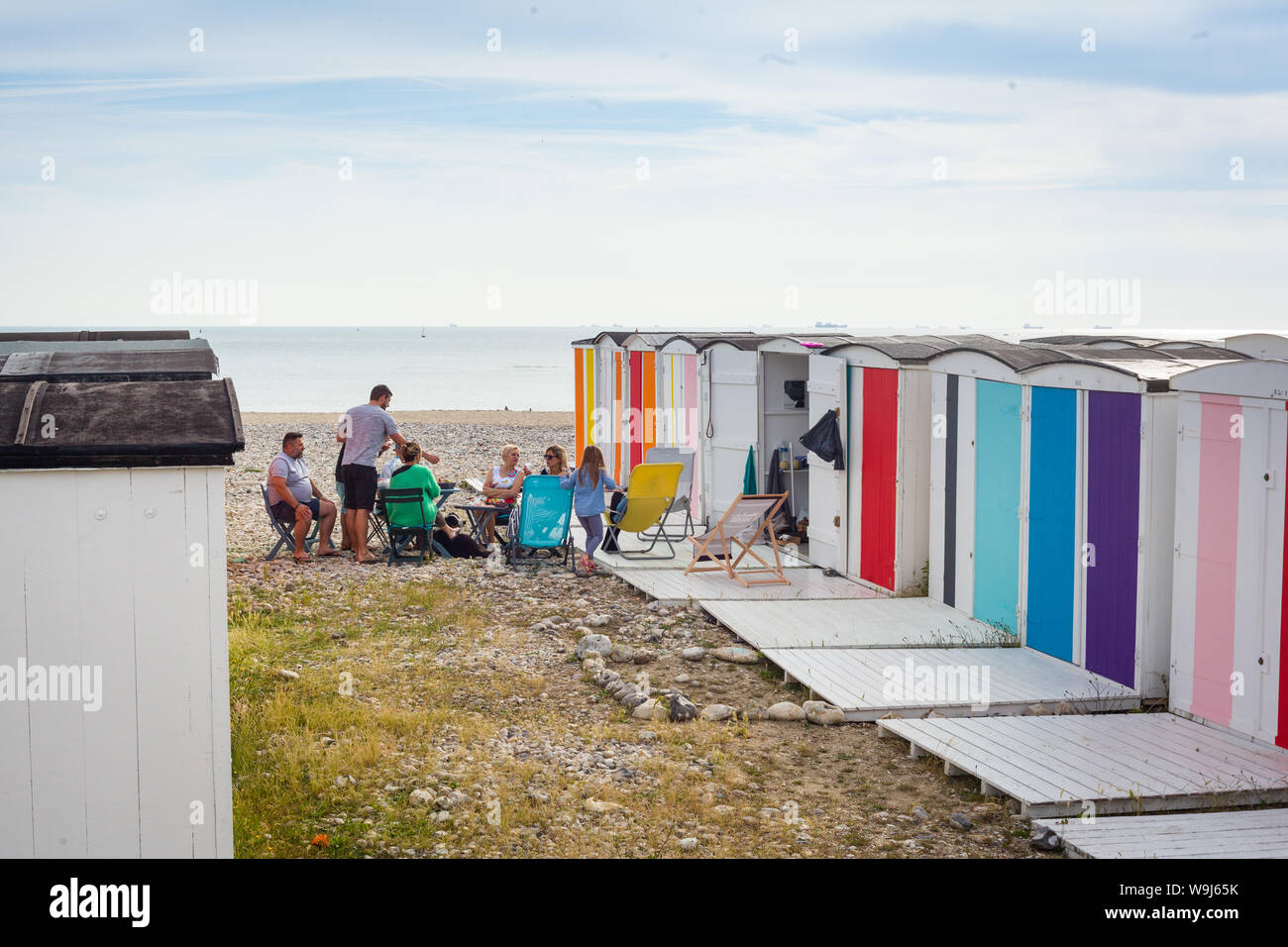 Un groupe de personnes qui profitent du soleil au bord de leurs cabanes de plage sur le front de mer à Sainte-adresse, le Havre, Normandie, France Banque D'Images