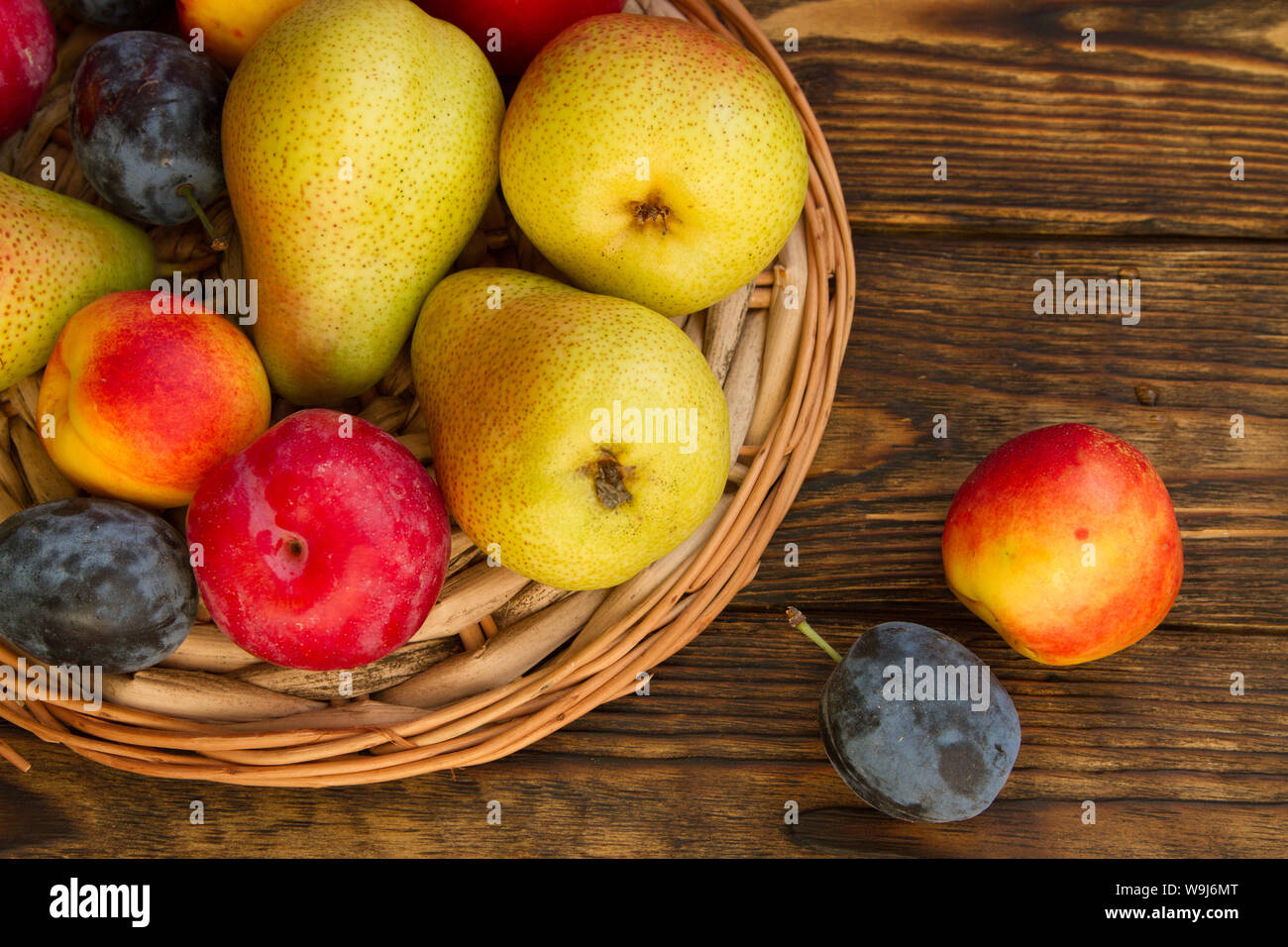 Poires mûres et prunes noires,rouge sur une table en bois,copy space Banque D'Images