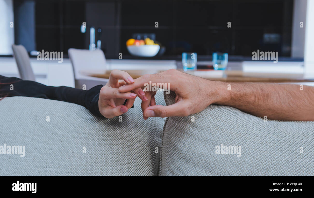 Couple heureux se tenant les mains, close-up. Wedding couple holding hands sur le canapé, à la maison Banque D'Images