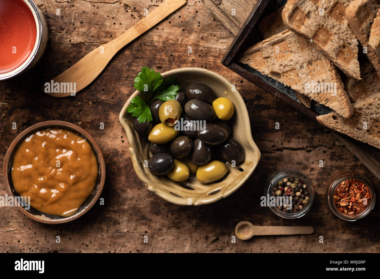 Olives vertes et noires et d'autres apéritifs sur table en bois Banque D'Images