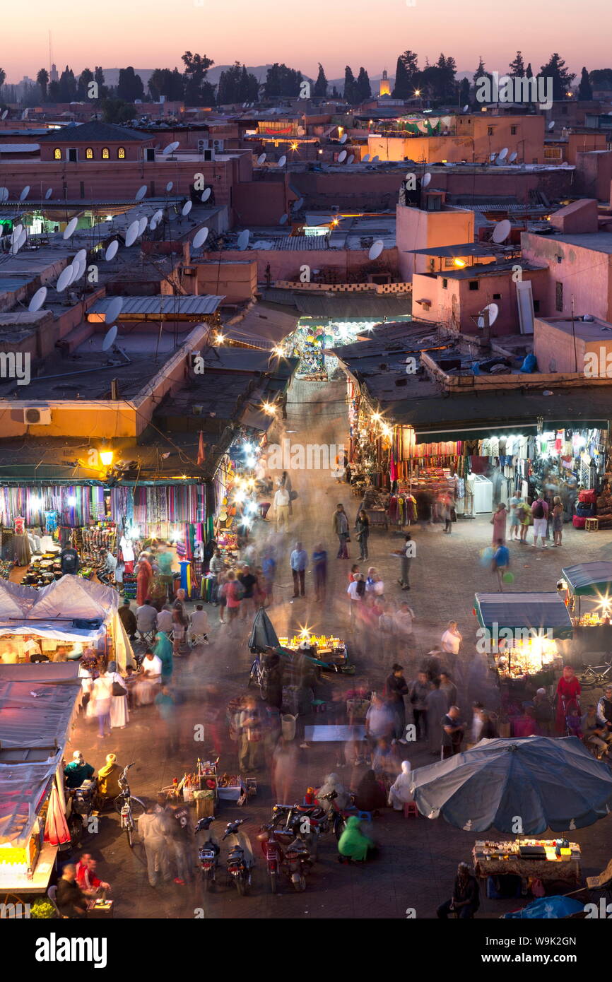 La foule des habitants et les touristes marcher parmi les boutiques et étals de la place Djemaa el Fna au coucher du soleil, Marrakech, Maroc, Afrique du Nord, Afrique Banque D'Images