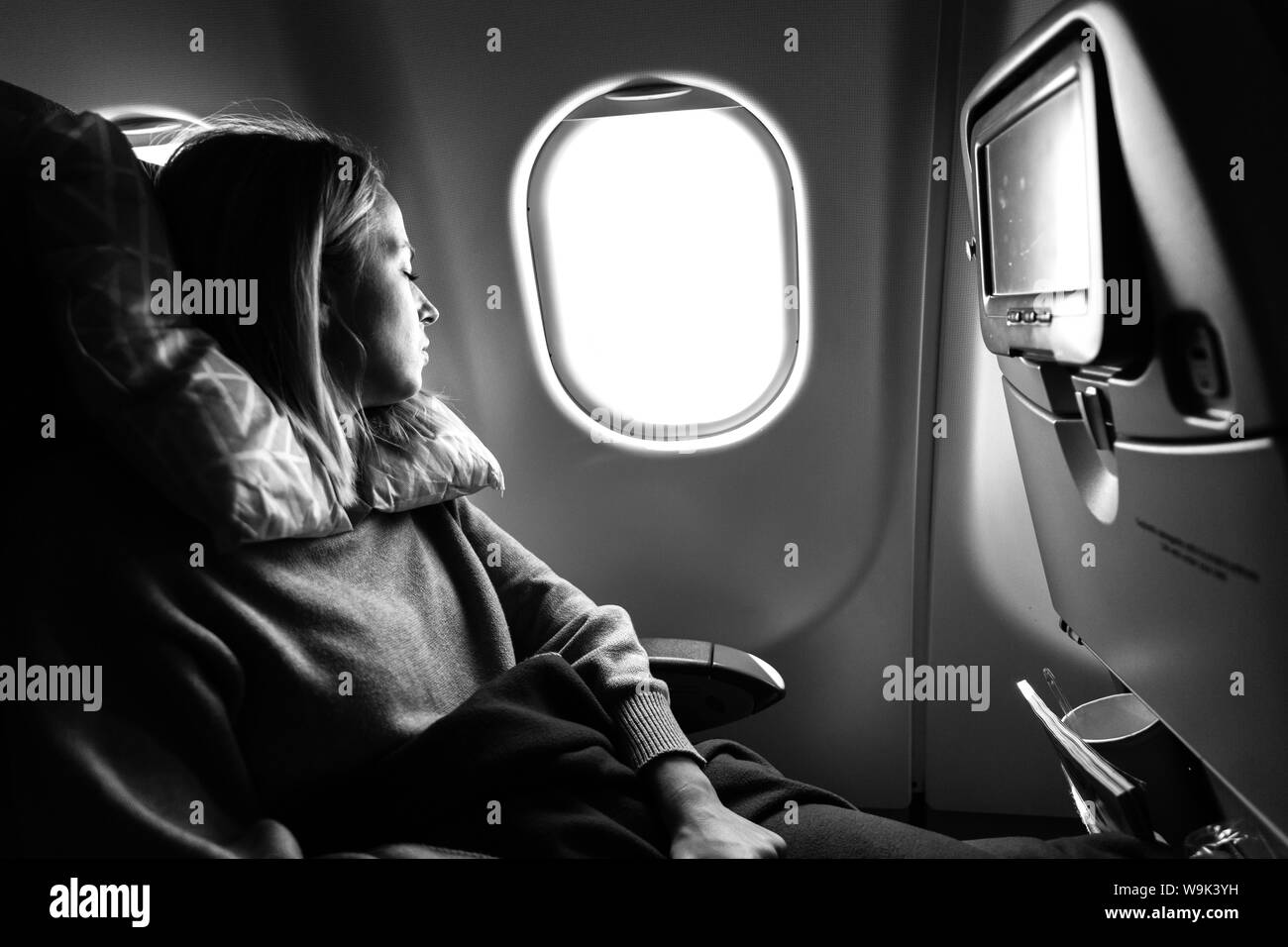Fatigué de race blanche occasionnels blonde dame sleepin sur siège alors qu'elles voyagent par avion. Transport commercial par avions. Banque D'Images