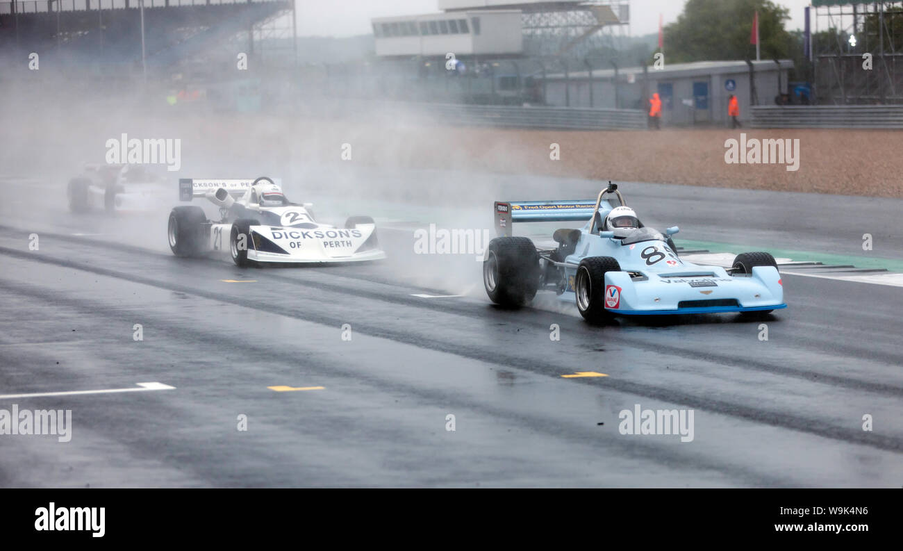 Frazer Gibney au volant de sa Chevron B40, conduit Matthew Watts dans sa March 722, sous la pluie, pendant la course de Formule 2 historiques HSCC au 2019 Silverstone Classic Banque D'Images