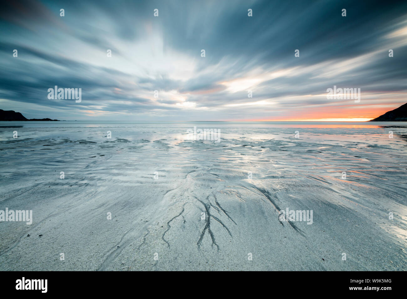 Soleil de minuit et les nuages frame la plage de sable de Skagsanden, Flakstad, comté de Nordland, îles Lofoten, Norvège, Scandinavie, Europe Banque D'Images