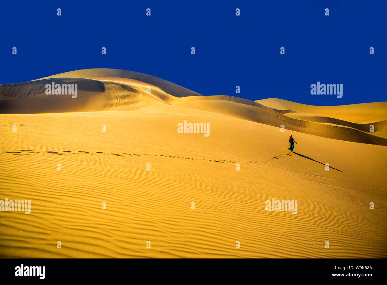 Femme marche sur dune de sable, Oasis de Huacachina, Pérou, Amérique du Sud Banque D'Images