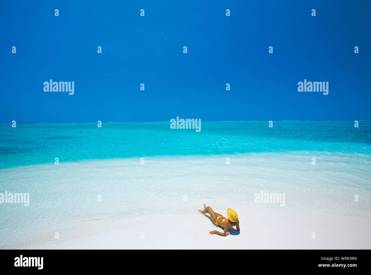 Femme lisant un livre sur la plage, Maldives, océan Indien, Asie Banque D'Images