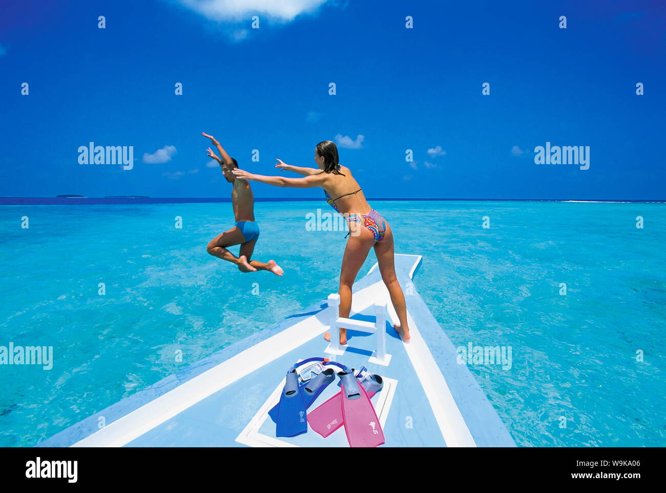 Couple à l'avant du bateau, l'homme sauter dans l'eau, les Maldives, l'Océan Indien, l'Asie Banque D'Images